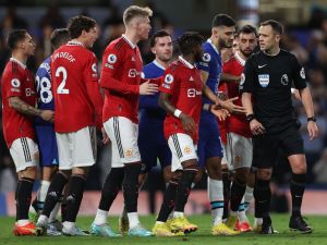 English referee Stuart Attwell (R) explains his penalty decision to players during the English Premier League football match between Chelsea and Manchester United at Stamford Bridge in London on October 22, 2022. (Photo by ADRIAN DENNIS / AFP) 