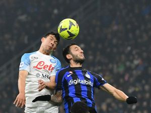 Napoli's Mexican forward Hirving Lozano (L) fights for the ball with Inter Milan's Turkish midfielder Hakan Calhanoglu during the Italian Serie A football match between Inter Milan and Napoli at Giuseppe Meazza stadium in Milan, on January 4, 2023 (Photo by Isabella BONOTTO / AFP)