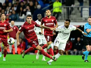 Sevilla's Argentinian forward Erik Lamela (L) fights for the ball with Real Madrid's Brazilian forward Rodrygo during the Spanish league football match between Real Madrid CF and Sevilla FC at the Santiago Bernabeu stadium in Madrid, on October 22, 2022. (Photo by JAVIER SORIANO / AFP)