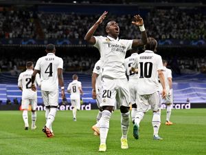Real Madrid's Brazilian forward Vinicius Junior celebrates with teammates scoring his team's first goal during the UEFA Champions League semi-final first leg football match between Real Madrid CF and Manchester City at the Santiago Bernabeu stadium in Madrid on May 9, 2023. (Photo by JAVIER SORIANO / AFP)