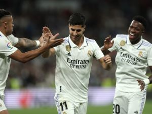 Real Madrid's Spanish midfielder Marco Asensio celebrates with Real Madrid's Brazilian forward Vinicius Junior (R) and Real Madrid's Dominican forward Mariano Diaz (L) scoring his team's first goal during the Spanish league football match between Real Madrid CF and Getafe CF at the Santiago Bernabeu stadium in Madrid on May 13, 2023. (Photo by Thomas COEX / AFP)