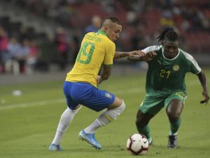 Senegal's Lamine Gassama (R) fights for the ball with Brazil's Everton (L) during the friendly international football match between Brazil and Senegal at the National Stadium in Singapore on October 10, 2019. / AFP / ROSLAN RAHMAN
