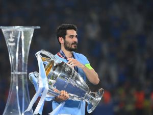 Manchester City's German midfielder #8 Ilkay Gundogan carries the European Cup trophy over to his teammates as they celebrate winning the UEFA Champions League final football match between Inter Milan and Manchester City at the Ataturk Olympic Stadium in Istanbul, on June 10, 2023. (Photo by FRANCK FIFE / AFP)
