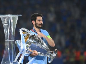 Manchester City's German midfielder #8 Ilkay Gundogan carries the European Cup trophy over to his teammates as they celebrate winning the UEFA Champions League final football match between Inter Milan and Manchester City at the Ataturk Olympic Stadium in Istanbul, on June 10, 2023. (Photo by FRANCK FIFE / AFP)