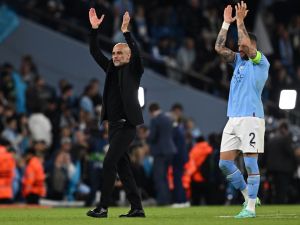 Manchester City's Spanish manager Pep Guardiola (L) and Manchester City's English defender Kyle Walker applauds the fans following the UEFA Champions League second leg semi-final football match between Manchester City and Real Madrid at the Etihad Stadium in Manchester, north west England, on May 17, 2023. Manchester City won the match 4-0. (Photo by Paul ELLIS / AFP)