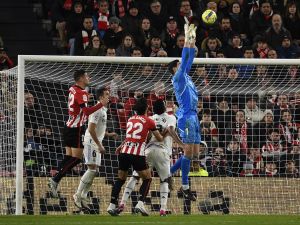 Real Madrid's Belgian goalkeeper Thibaut Courtois (R) jumps for the ball during the Spanish league football match between Athletic Club Bilbao and Real Madrid CF at the San Mames stadium in Bilbao, on January 22, 2023. (Photo by ANDER GILLENEA / AFP)