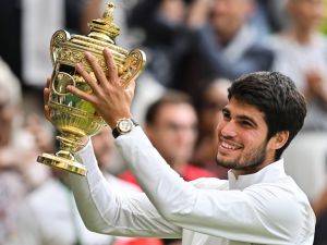 Spain's Carlos Alcaraz raises the winner's trophy after beating Serbia's Novak Djokovic during their men's singles final tennis match on the last day of the 2023 Wimbledon Championships at The All England Tennis Club in Wimbledon, southwest London, on July 16, 2023. (Photo by Glyn KIRK / AFP)