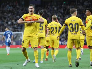 Barcelona's Polish forward Robert Lewandowski (L) celebrates scoring the opening goal during the Spanish league football match between RCD Espanyol and FC Barcelona at the RCDE Stadium in Cornella de Llobregat on May 14, 2023. (Photo by Lluis GENE / AFP)