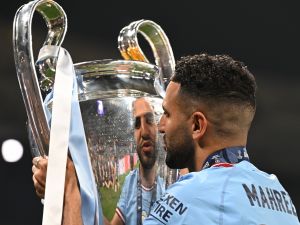 Manchester City's Algerian midfielder #26 Riyad Mahrez poses with the European Cup trophy as they celebrate winning the UEFA Champions League final football match between Inter Milan and Manchester City at the Ataturk Olympic Stadium in Istanbul, on June 10, 2023. Manchester City won the match 1-0. (Photo by Paul ELLIS / AFP)