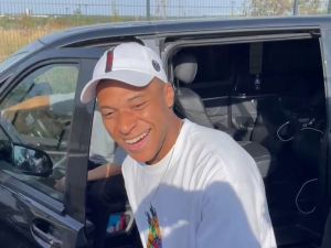 A video image grab shows Paris Saint-Germain's forward Kylian Mbappe as he stops at the entrance of the Paris Saint-Germain training grounds to meet with fans and sign autographs, after a training session in Poissy, western suburbs of Paris, on July 22, 2023. (Photo by Tom MASSON / AFP)