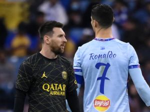 Paris Saint-Germain's Argentine forward Lionel Messi (L) walks past Riyadh All-Star's Portuguese forward Cristiano Ronaldo (R) during the Riyadh Season Cup football match between the Riyadh All-Stars and Paris Saint-Germain at the King Fahd Stadium in Riyadh on January 19, 2023. (Photo by FRANCK FIFE / AFP)