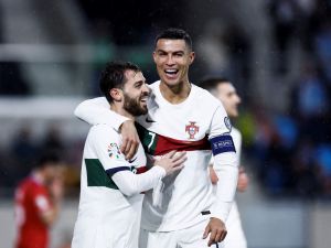 Portugal's forward Cristiano Ronaldo (R) celebrates after opening the scoring with Portugal's midfielder Bernardo Silva during the UEFA Euro 2024 group J qualification football match between Luxembourg and Portugal at the Stade de Luxembourg, in Luxembourg, on March 26, 2023. (Photo by Kenzo TRIBOUILLARD / AFP)