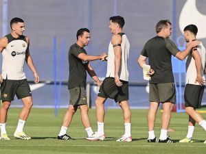 Barcelona's Spanish coach Xavi (2L) shakes hands with Barcelona's Polish forward #9 Robert Lewandowski (C) next to Barcelona's Spanish forward #07 Ferran Torres (L) during a training session at the Joan Gamper training ground in Sant Joan Despi, near Barcelona, on August 12, 2023, on the eve of their first Spanish Liga football match of this season, against Getafe CF. (Photo by Pau BARRENA / AFP)