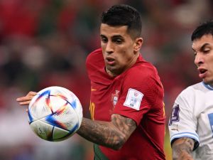 Portugal's defender #20 Joao Cancelo (L) and Uruguay's defender #16 Mathias Olivera fight for the ball during the Qatar 2022 World Cup Group H football match between Portugal and Uruguay at the Lusail Stadium in Lusail, north of Doha on November 28, 2022. (Photo by Kirill KUDRYAVTSEV / AFP)