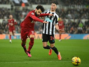 Liverpool's Egyptian striker Mohamed Salah (L) fights for the ball with Newcastle United's Paraguayan midfielder Miguel Almiron during the English Premier League football match between Newcastle United and Liverpool at St James' Park in Newcastle-upon-Tyne, north east England on February 18, 2023. (Photo by Oli SCARFF / AFP)