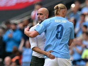 Manchester City's Spanish manager Pep Guardiola (L) gestures to Manchester City's Norwegian striker Erling Haaland (R) as he leaves the game, substituted during the English FA Community Shield football match between Arsenal and Manchester City at Wembley Stadium, in London, August 6, 2023. (Photo by Glyn KIRK / AFP)