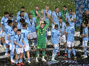 Manchester City's players celebrate on the podium after winning the 2023 UEFA Super Cup football match between Manchester City and Sevilla at the Georgios Karaiskakis Stadium in Piraeus on August 16, 2023. (Photo by Angelos Tzortzinis / AFP)