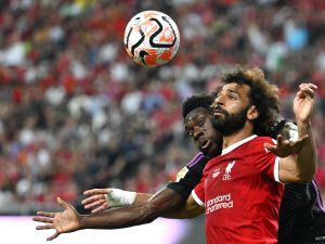 Liverpool's Egyptian striker Mohamed Salah (front) fights for the ball against Bayern Munich's Canadian midfielder Alphonso Davies during the Singapore Festival of Football pre-season friendly match in Singapore on August 2, 2023. (Photo by MOHD RASFAN / AFP)