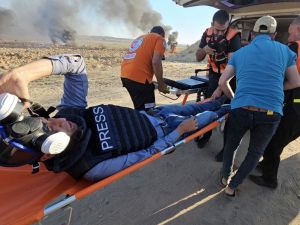 مصور وكالة الصحافة الفرنسية بلال الصباغ اثناء نقله الى سيارة اسعاف بعد اصابته خلال تغطيته التظاهرات قرب حدود غزة