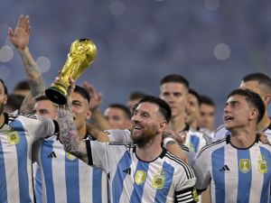ميسي يحتفل بكأس العالم Argentina's forward Lionel Messi (C) raises a replica of the World Cup trophy next to his teammates during a recognition ceremony for the World Cup-winning players, following the friendly football match between Argentina and Curacao at the Madre de Ciudades stadium in Santiago del Estero, in northern Argentina, on March 28, 2023. (Photo by JUAN MABROMATA / AFP)