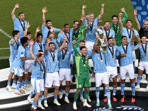 Manchester City's players celebrate on the podium after winning the 2023 UEFA Super Cup football match between Manchester City and Sevilla at the Georgios Karaiskakis Stadium in Piraeus on August 16, 2023. (Photo by Angelos Tzortzinis / AFP)