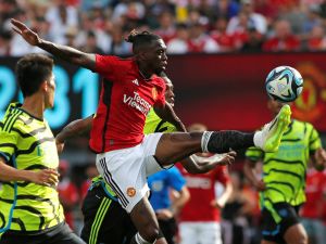 Manchester United's English defender Aaron Wan-Bissaka (C) fights for the ball with Arsenal's Japanese defender Takehiro Tomiyasu (L) and Arsenal's Brazilian defender Gabriel (R) during the friendly football match between Manchester United and Arsenal at MetLife Stadium in East Rutherford, New Jersey, on July 22, 2023. (Photo by Leonardo Munoz / AFP)