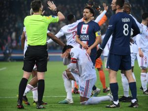 Lyon's French midfielder Corentin Tolisso grimaces next to the referre and Paris Saint-Germain's Brazilian defender Marquinhos during the French L1 football match between Paris Saint-Germain (PSG) and Olympique Lyonnais (OL) at The Parc des Princes Stadium in Paris on April 2, 2023. (Photo by FRANCK FIFE / AFP)