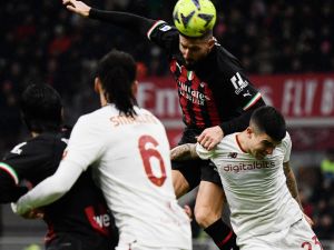 AC Milan's French forward Olivier Giroud (C) goes for a header next to AS Roma's Italian defender Gianluca Mancini (R) during the Italian Serie A football match between AC Milan and AS Roma, at the San Siro stadium in Milan, on January 8, 2023. (Photo by Filippo MONTEFORTE / AFP)