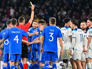 Serbian referee Srdjan Jovanovic (3rdL) gives a yellow card to England's defender Kyle Walker (not in picture) during the UEFA Euro 2024 Group C qualification match between Italy and England, on March 23, 2023 at the Diego-Maradona stadium in Naples. (Photo by Alberto PIZZOLI / AFP)