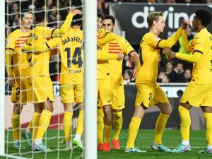Barcelona's Portuguese forward #14 Joao Felix celebrates scoring the opening goal, with teammates, during the Spanish league football match between Valencia CF and FC Barcelona at the Mestalla stadium in Valencia on December 16, 2023. (Photo by JOSE JORDAN / AFP)