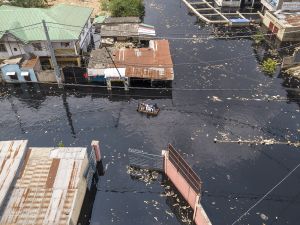 aerial view shows people crossing the floodwaters of the Carrigres bridge in the Pompage district in Kinshasa. (Photo by Arsene Mpiana / AFP)  Congo