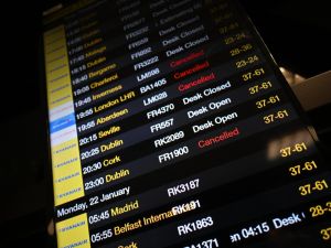 The arrivals board at Manchester Airport shows many flights cancelled or delayed due to high winds caused by Storm Isha on January 21, 2024. Amber warnings for wind were in place in the UK on Sunday, as Storm Isha approached the country. (Photo by Paul ELLIS / AFP) StormIsha
