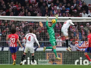 Sevilla's Moroccan forward #15 Youssef En-Nesyri challenges Atletico Madrid's Slovenian goalkeeper #13 Jan Oblak during the Spanish league football match between Club Atletico de Madrid and Sevilla FC at the Metropolitano stadium in Madrid on December 23, 2023. (Photo by Pierre-Philippe MARCOU / AFP)