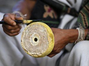 An Arhuaco Indigenous holds their traditional "Poporo," a small dried gourd containing lime made from crushed seashells with which they boost the alkaloids of the coca leaf that they chew continuously. (Photo by Raul ARBOLEDA / AFP) indigenous communities
