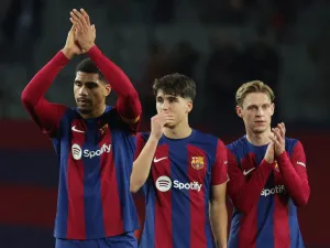 Barcelona's Uruguayan defender #04 Ronald Araujo (L) claps, next to Barcelona's Spanish defender #33 Pau Cubarsi and Barcelona's Dutch midfielder #21 Frenkie de Jong (R) at the end of during the Spanish league football match between FC Barcelona and CA Osasuna at the Estadi Olimpic Lluis Companys in Barcelona on January 31, 2024. (Photo by LLUIS GENE / AFP)