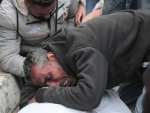 رجل فلسطيني ينعي جثة قريب له استشهد خلال القصف الإسرائيلي على دير البلح