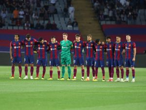 Players observe a minute of silence in tribute to late Argentinian coach Cesar Luis Menotti prior the Spanish league football match between FC Barcelona and Real Sociedad at the Estadi Olimpic Lluis Companys in Barcelona on May 13, 2024. (Photo by LLUIS GENE / AFP)