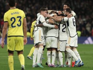 Real Madrid's players celebrate their second goal scored by Brazilian forward #11 Rodrygo during the Spanish league football match between Real Madrid CF and Villarreal CF at the Santiago Bernabeu stadium in Madrid on December 17, 2023. (Photo by Thomas COEX / AFP)