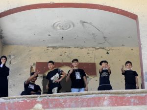 أطفال لبنانيون يرفعون شارة النصر من داخل منزلهم المدمر في جنوب لبنان