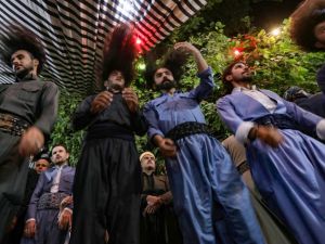 أشخاص بشعور طويلة ويرتدون أزياء موحدة، يؤدون ما يشبه الطقوس الدينية
