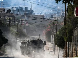 An Israeli military vehicle drives in the occupied West Bank city of Jenin amid ongoing Israeli raids on August 31, 2024. (Photo by RONALDO SCHEMIDT / AFP)