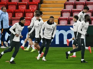Real Madrid's English midfielder #5 Jude Bellingham (L) and Real Madrid's French forward #09 Kylian Mbappe (C) take part in a training session, at Anfield Stadium in Liverpool, north west England, on November 26, 2024, on the eve of their UEFA Champions League football match against Liverpool. (Photo by Paul ELLIS / AFP)