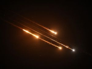 Debris of missiles fired from Iran toward Israel leave trails in the night sky over Nablus in the occupied West bank after being intercepted on June 13, 2025
