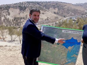 Israeli far-right Finance Minister Bezalel Smotrich displays a map of an area near the settlement of Maale Adumim, a land corridor known as E1, outside Jerusalem in the occupied West Bank, on August 14, 2025, after a press conference at the site. AFP Israeli Knesset narrowly backs West Bank annexation bills despite Netanyahu opposition
