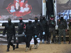 Palestinian militants carry one of the coffins as they hand over the bodies of four Israeli hostages to the Red Cross in Khan Yunis in the southern Gaza on February 20, 2025. Hamas handed over on February 20 coffins believed to contain the bodies of four Israeli hostages, including those of the Bibas family who became symbols of the ordeal that has gripped Israel since the Gaza war began. The transfer of the bodies is the first by Hamas since its October 7, 2023 attack on Israel triggered the war (Photo by Eyad BABA / AFP) Countdown to closure: Israel braces for new hostage remains from Gaza