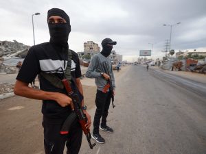Israel declared a ceasefire in Gaza and began to pull back its forces on October 10, as tens of thousands of exhausted Palestinians made their way back to their devastated homes. Members of the internal security forces loyal to the Palestinian group Hamas, man a checkpoint in the Nuseirat refugee camp in the central Gaza Strip, on October 12, 2025. (AFP) Clashes erupt in Gaza city as interior ministry confronts armed militia