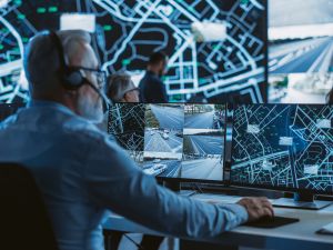 Technical Customer Support Specialist is Talking on a Headset while Working on a Computer in a Call Center Control Room Filled Display Screens with Monitoring Software. Over the Shoulder Footage (Shutterstock ) Technical Customer Support Specialist is Talking on a Headset while Working on a Computer in a Call Center Control Room Filled Display Screens with Monitoring Software. Over the Shoulder Footage
