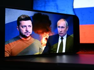 رئيس أوكرانيا فولوديمير زيلينسكي على شاشة الهاتف الذكي ورئيس روسيا فلاديمير بوتين.