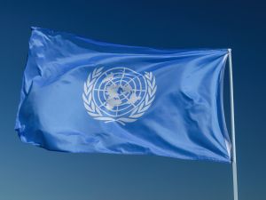 علم الأمم المتحدة. علم الأمم المتحدة على خلفية السماء. شعار الأمم المتحدة.