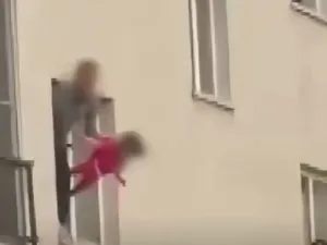 رجل يعلق ابنته البالغة من العمر ثلاث سنوات من النافذة كرهينة، ويُهددها بسكين 
